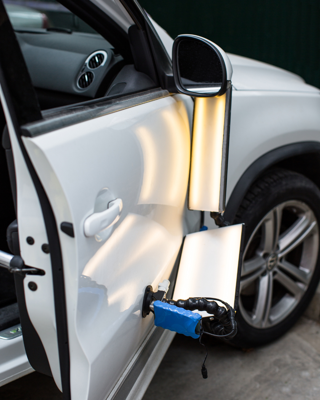 white car door is being treated for dents